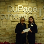 DuPage Foundation Trustee Betsy Brosnan (L) awards grant to Ashley Downing of the DuPage County Historical Museum Foundation at a special distribution Open House, Wednesday, December 16, 2015. Photo © DuPage Foundation.