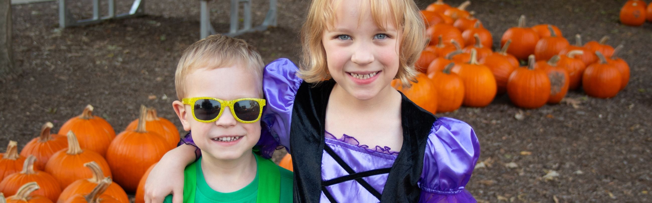 two children in front of pumpkins