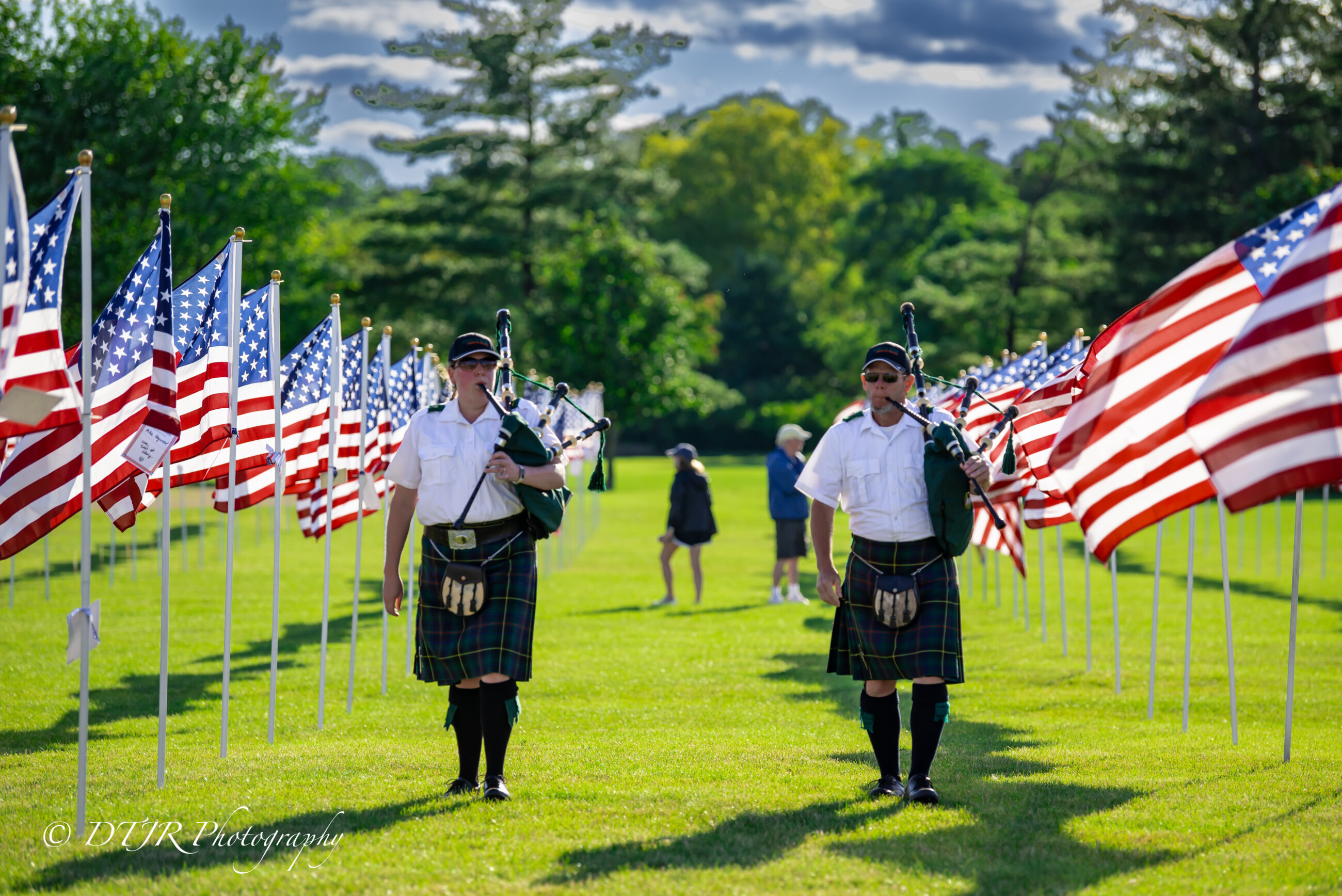 Field-of-Honor-Focus-Image Two people playing bagpipes between rows of United States flags