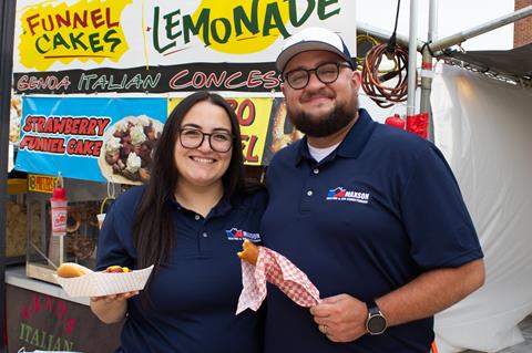 FoodVendors-COW-Press-Release Two Food Vendors in front of a food stall with hotdogs and lemonade.