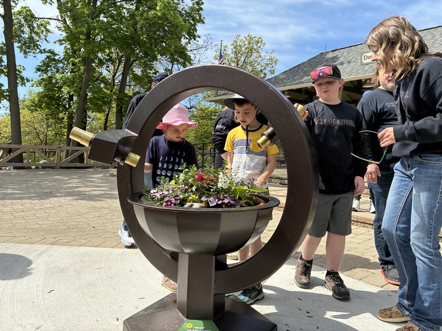 a Kaleidoscope outdoors with children observing flowers
