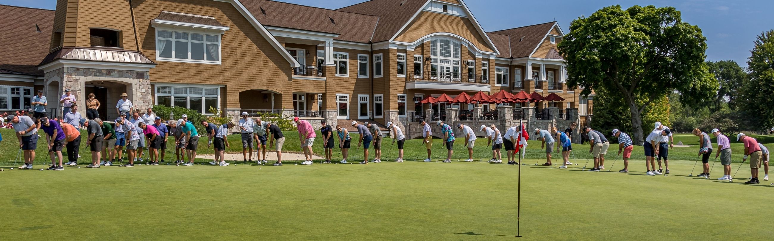 A line of golfers aiming for the hole.