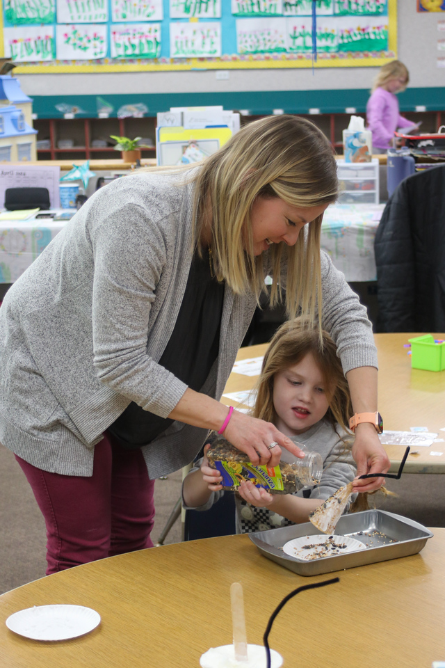 Wide-Horizons-Class Preschool teacher assists child with craft project