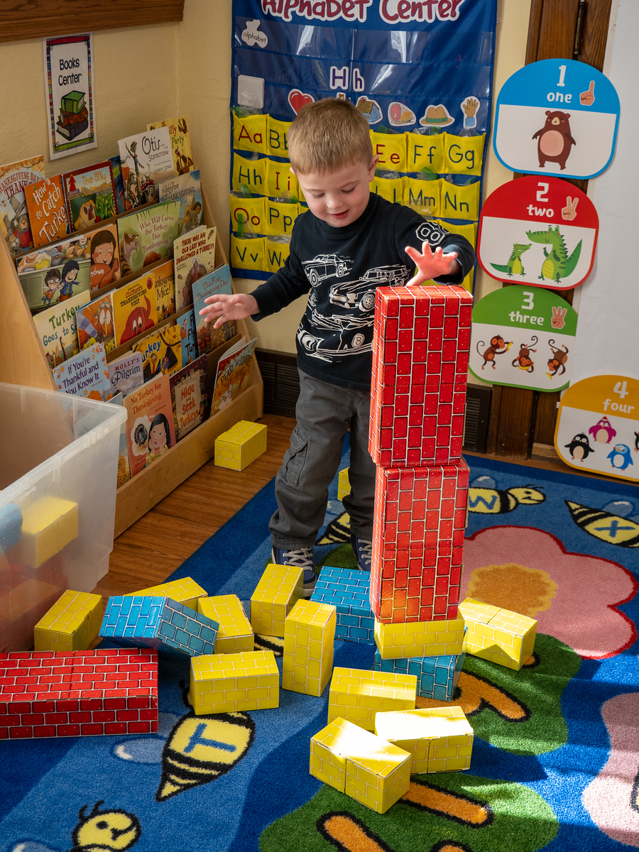 i-Xcqskn2-X3 Preschool teacher assists child with craft project