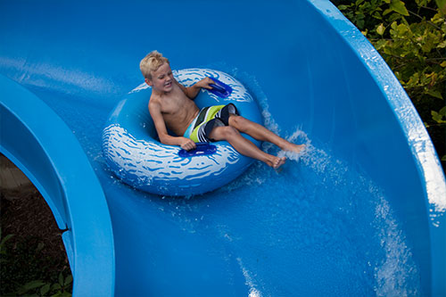 Little buy on a float sliding down water slide