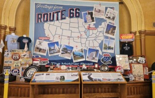 Route 66 display with map, memorabilia, classic car model, and informational kiosks.